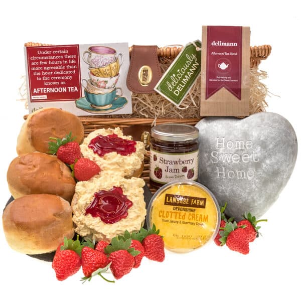 A Home Sweet Home Devon Cream Tea wicker basket filled with Devon Cream Tea delights - scones, jam, and strawberries with a home sweet home door stop in grey heart